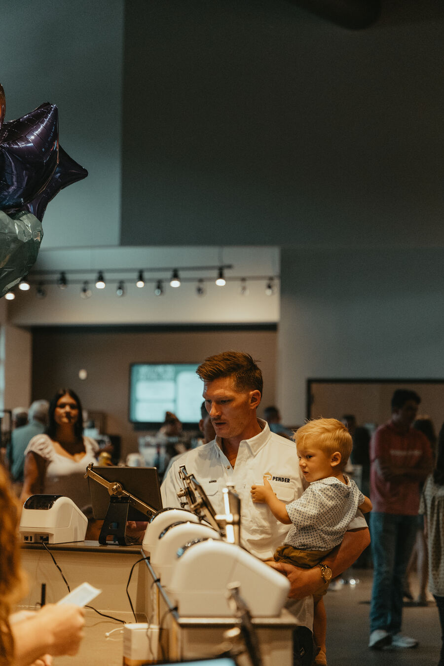 A man holding a toddler at the welcome table.