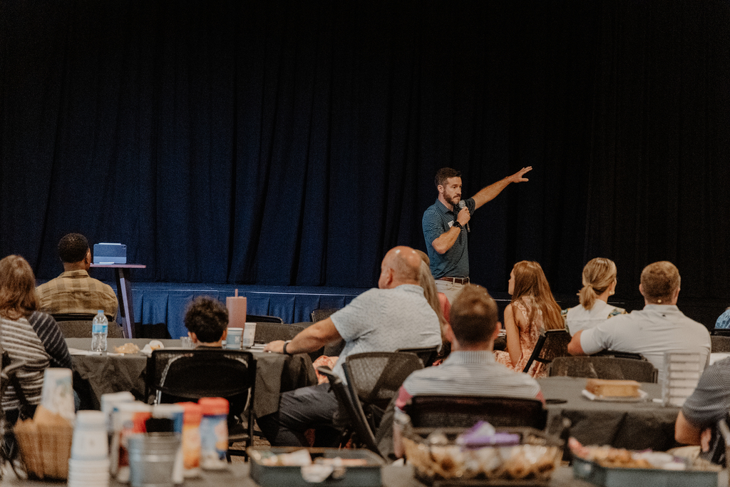 A Discover Warren session, the speaker on the stage above the tables.
