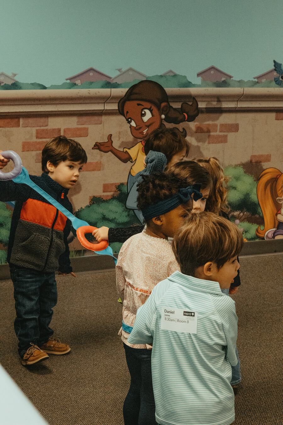Children playing together by the mural wall.