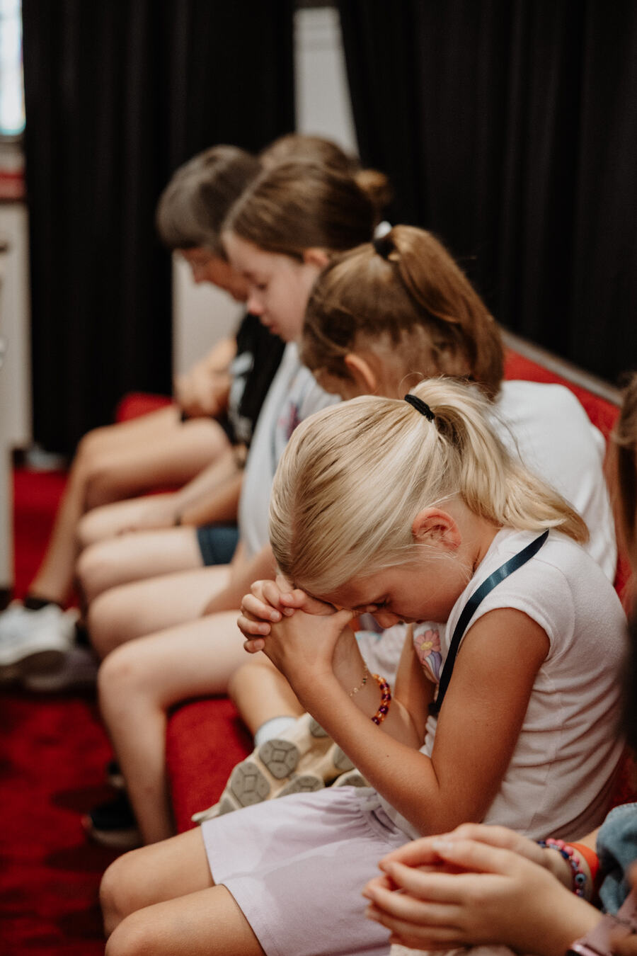 Children praying together in the pews.