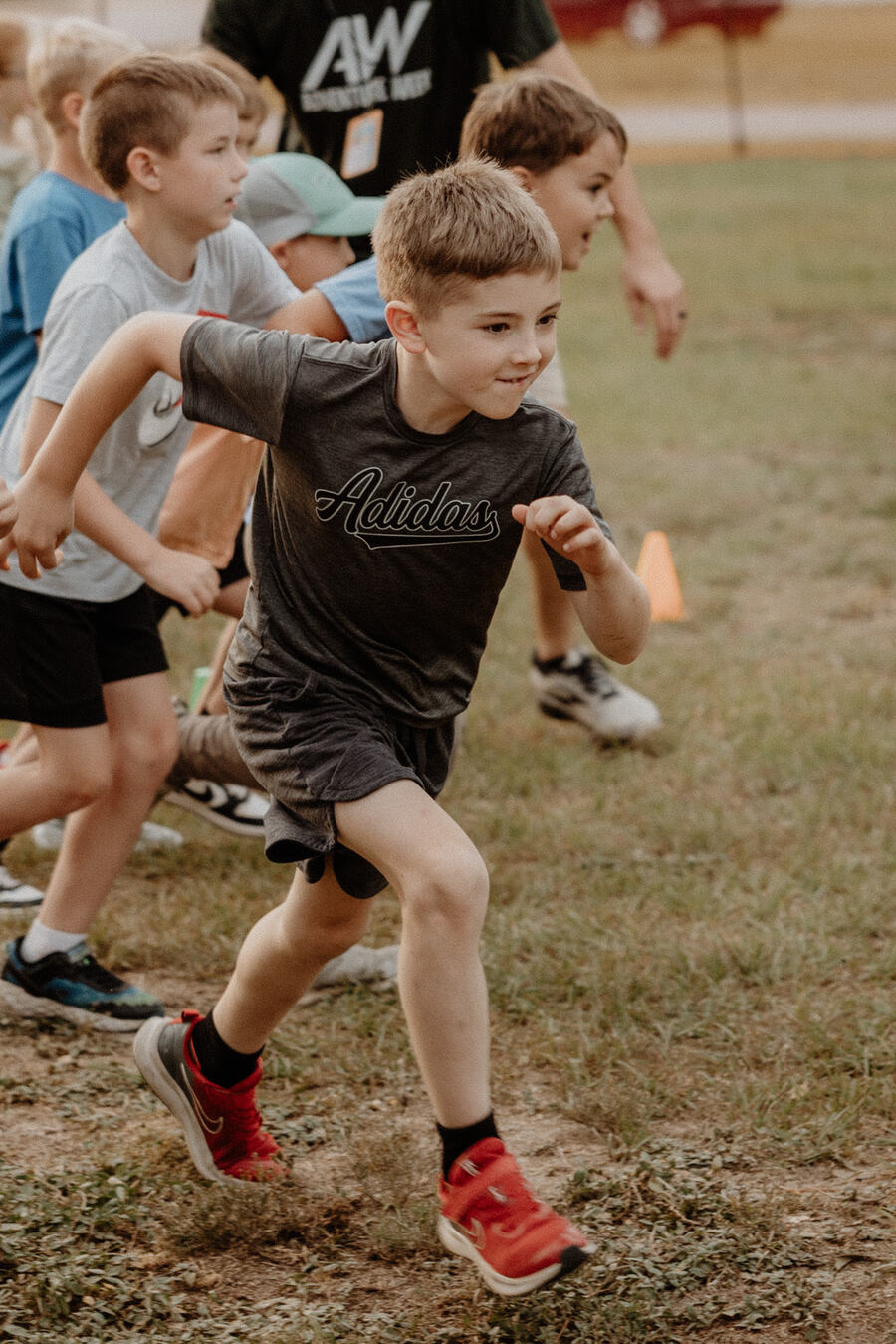 Children running outside on the grass.