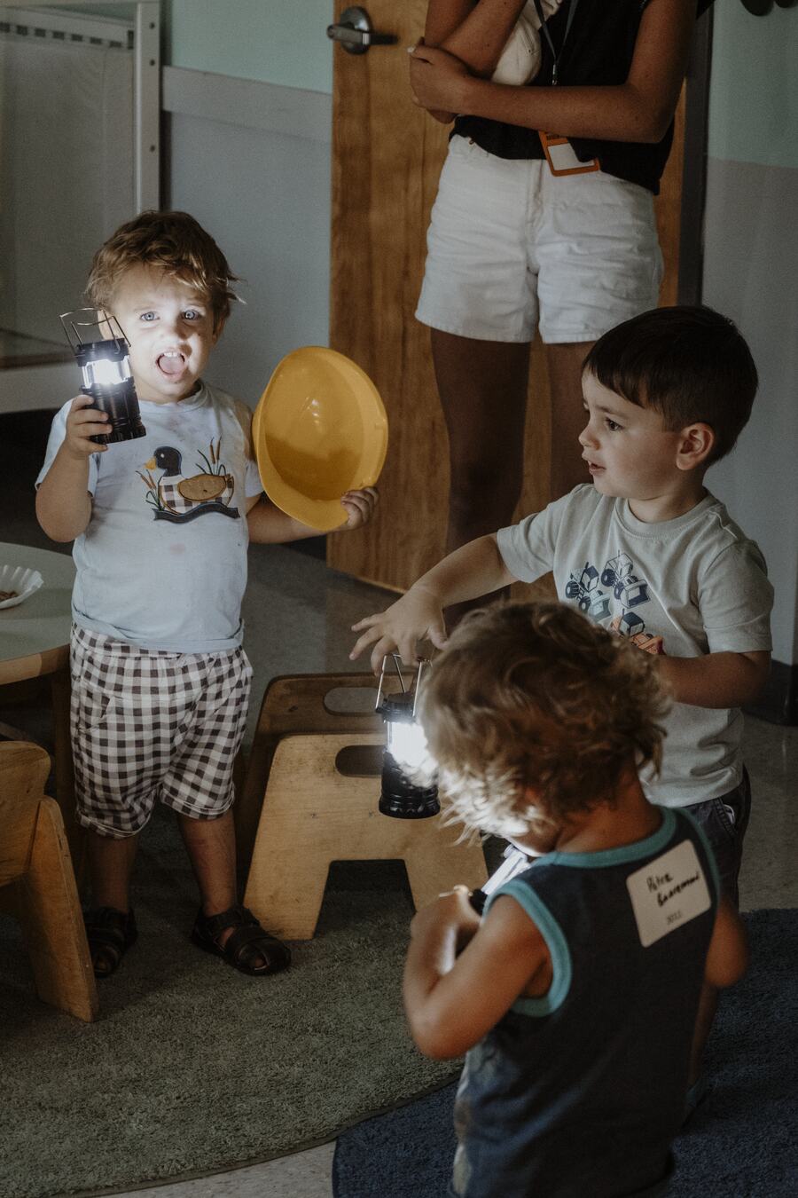Toddlers exploring with lanterns.