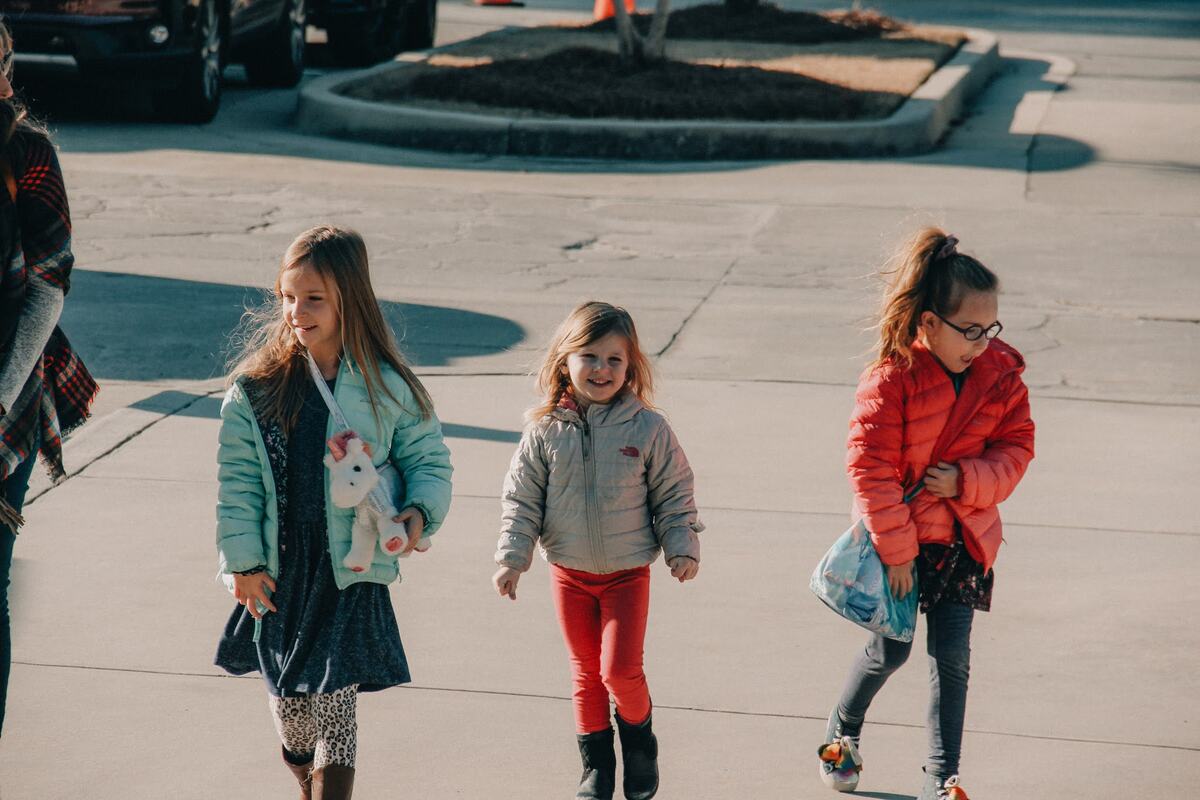 Three children walking up together.