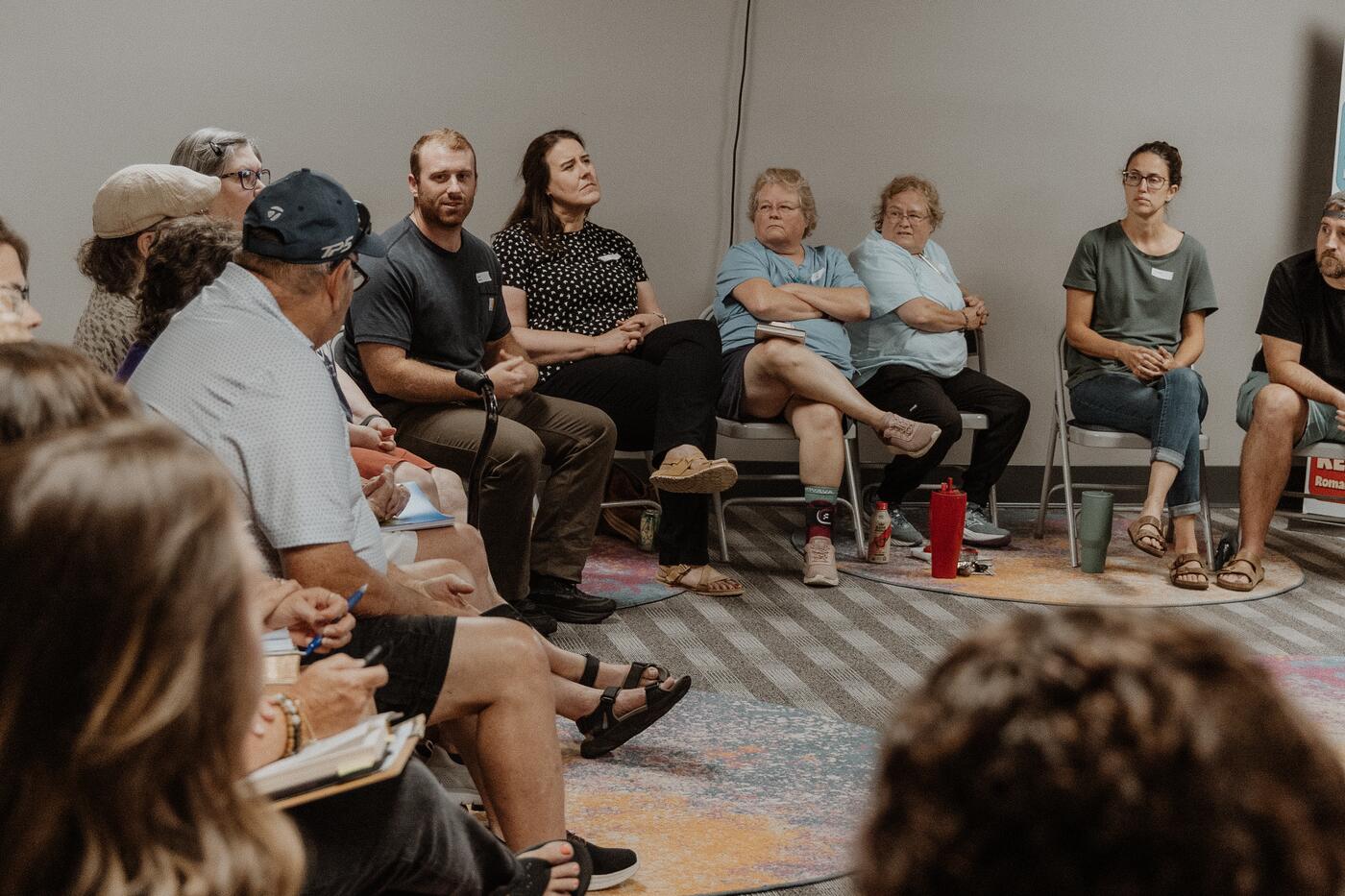 A group talking together in a circle of chairs.