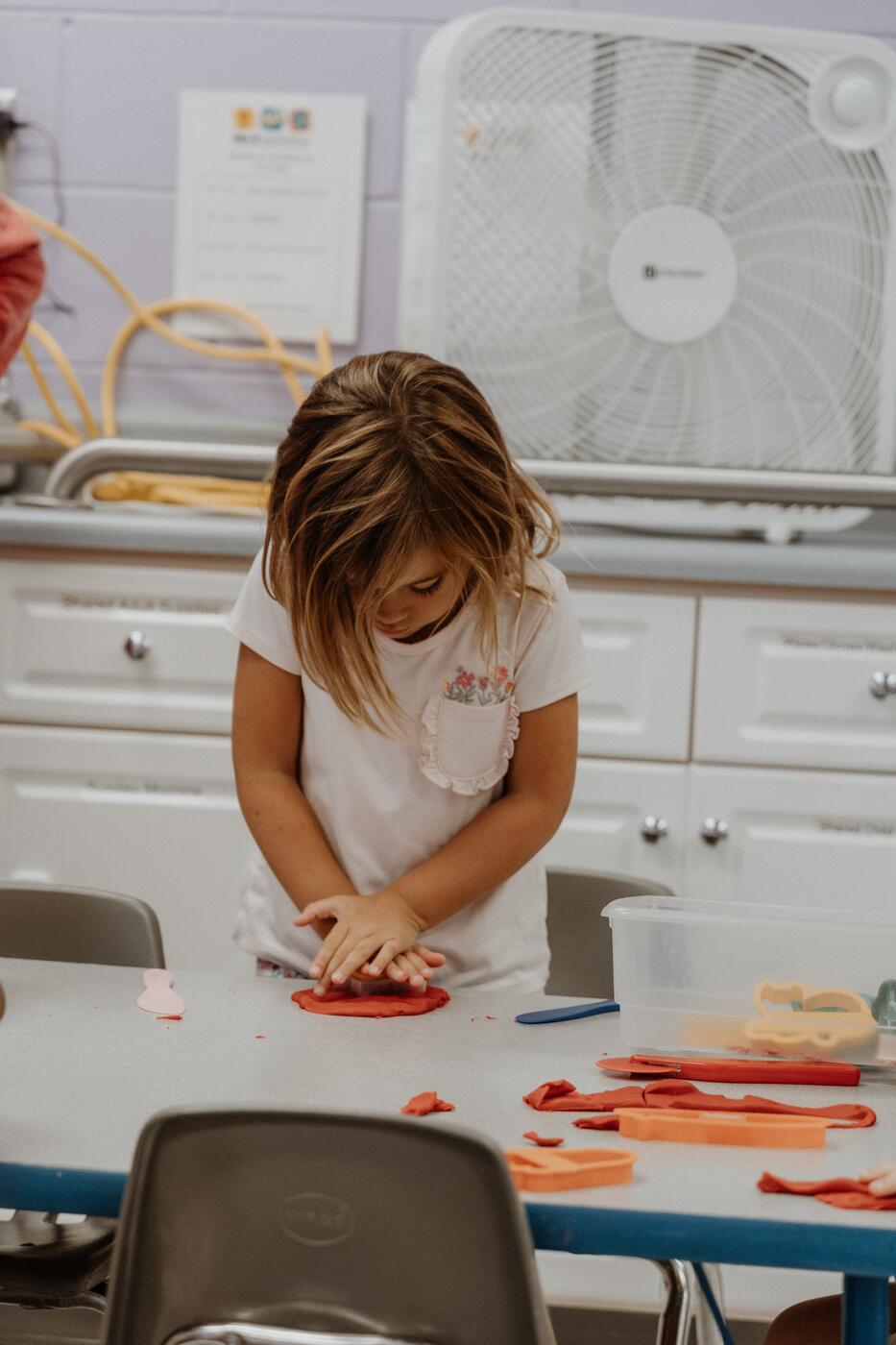 A child working on a craft at the table.