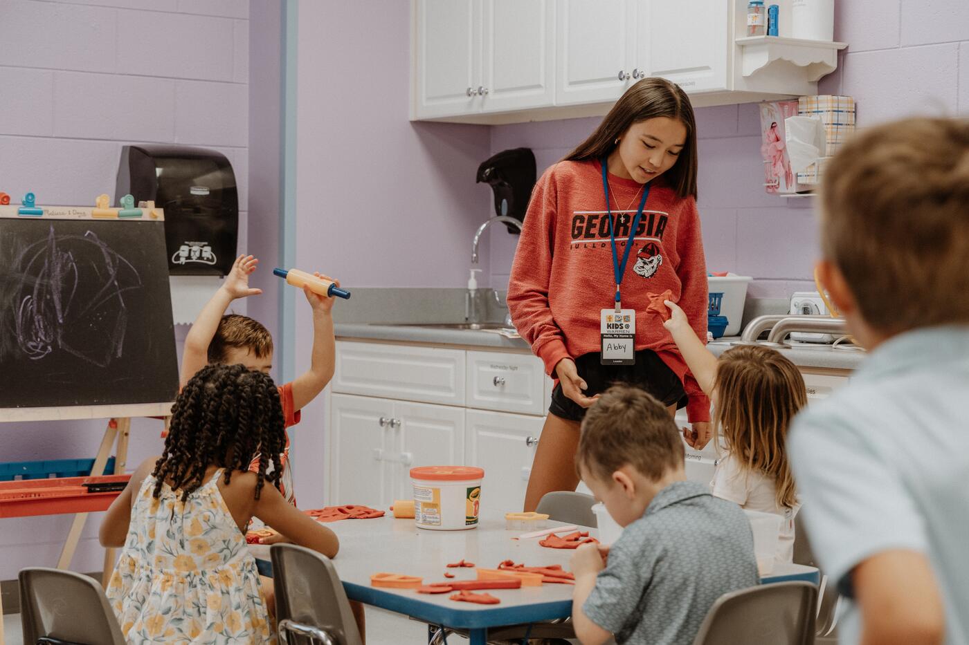 Children and a leader around a table with an activity.