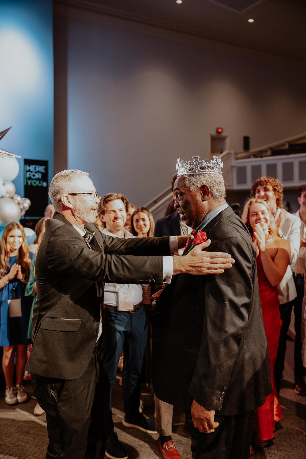 A volunteer welcoming a crowned guest.