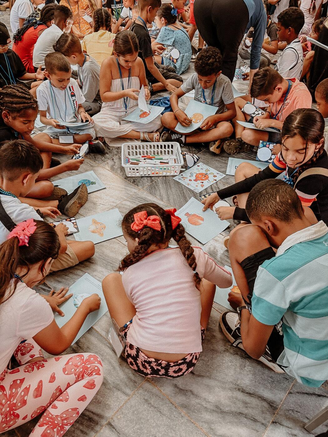 Children working on crafts together on the floor.