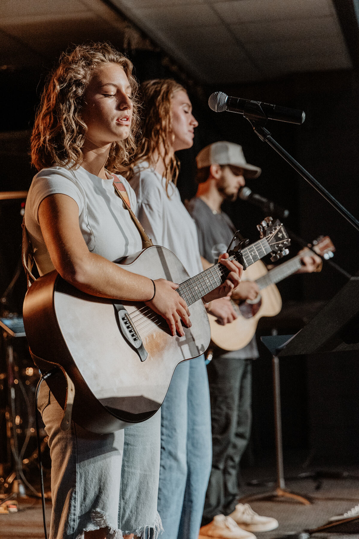 Two students singing with a guitarist.