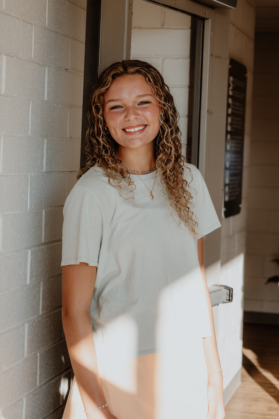 A student smiling against the wall.