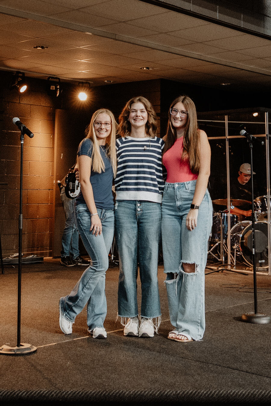 Three students together on the stage.