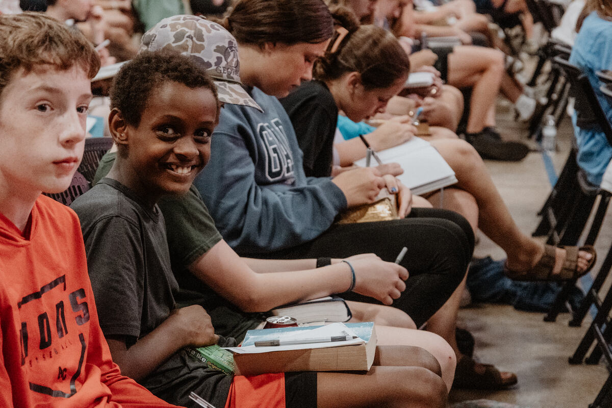 Middle school students taking notes during the message.