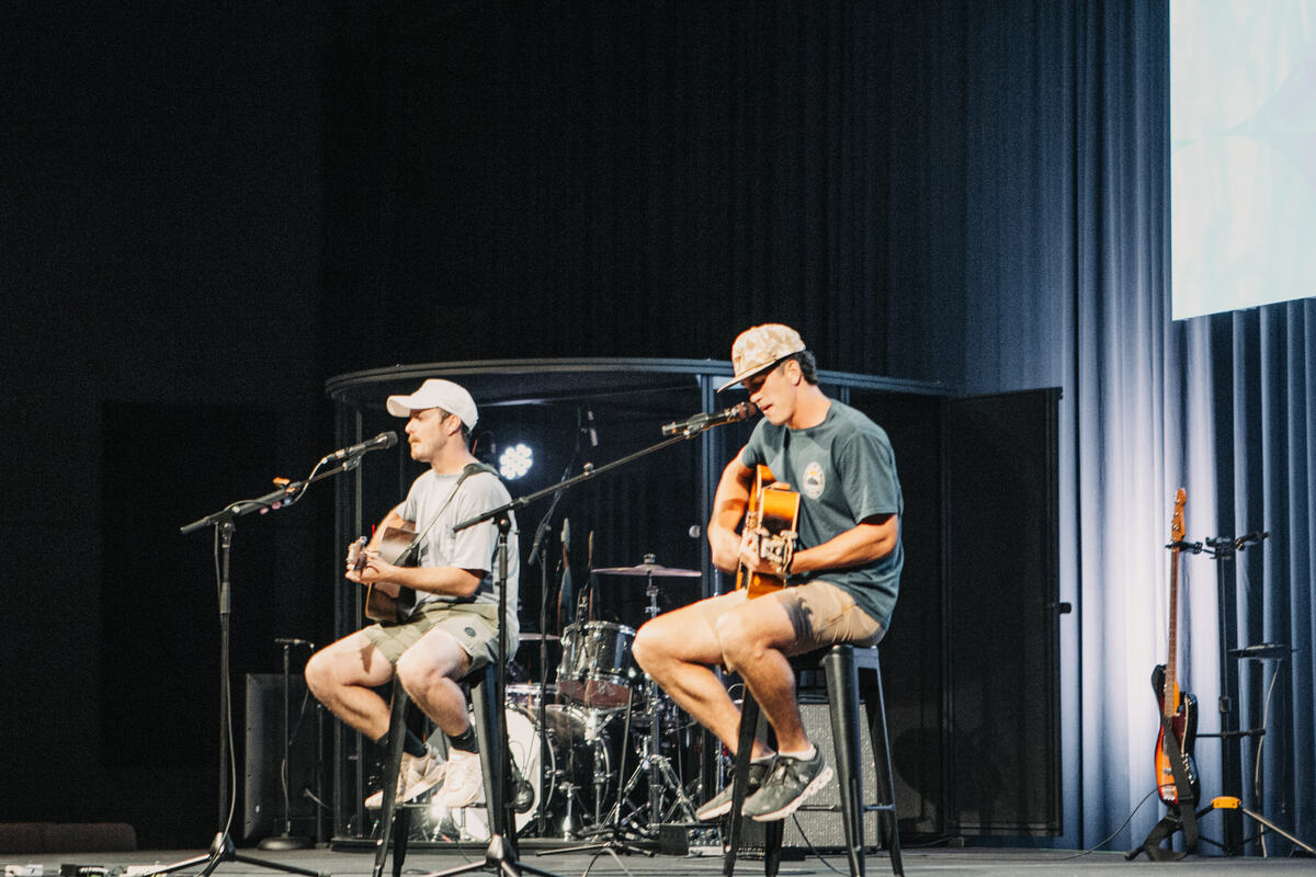 Two students playing guitar on stage.
