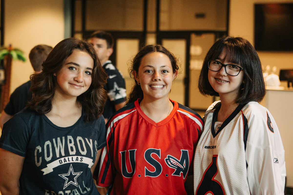Three students in jerseys, smiling.