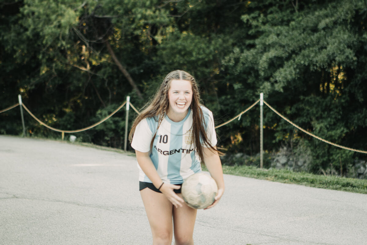 A student outside with a ball.