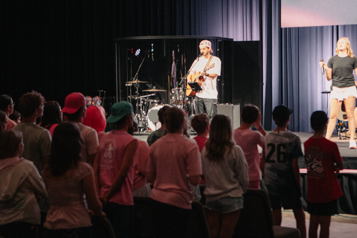Students standing for worship as the band plays.