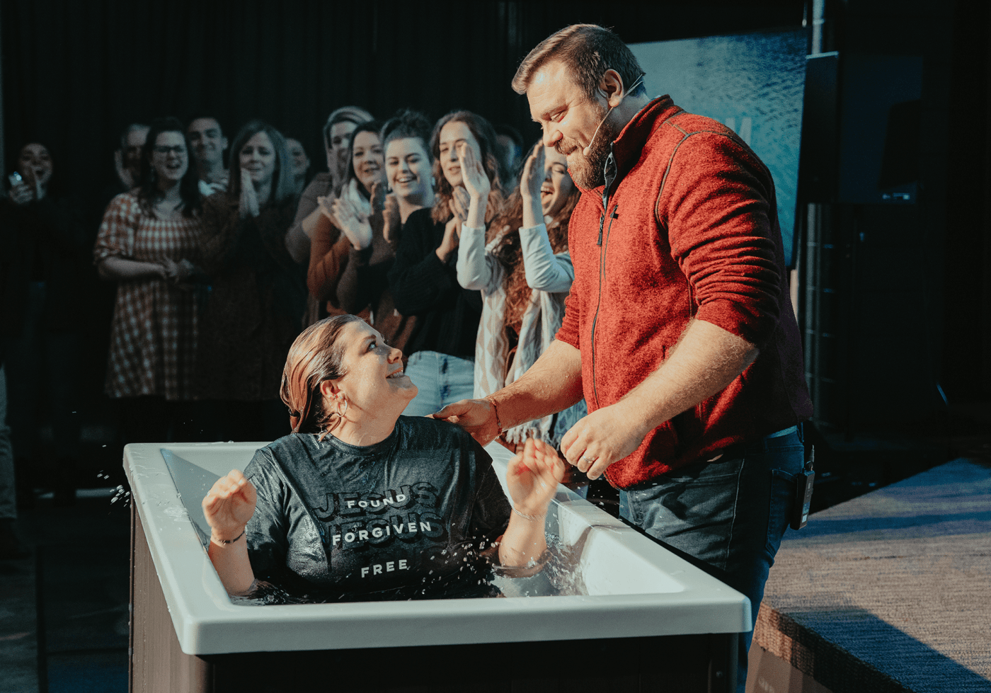 A baptism at Warren, friends applauding behind the baptistry.