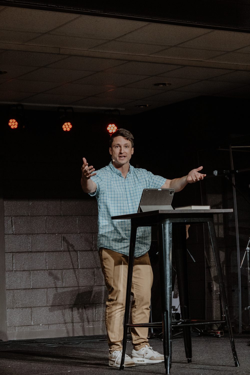 A man speaking from a stand at the front of the room.